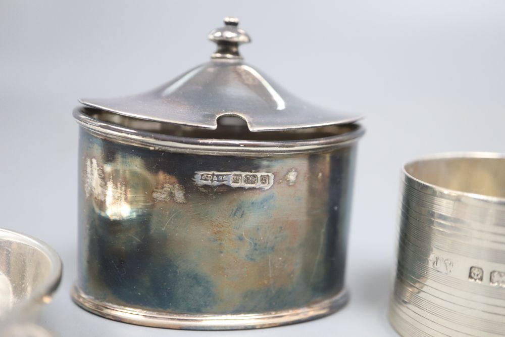 A silver tea strainer, a silver serviette ring and five various silver condiments, 8oz (excluding liners)